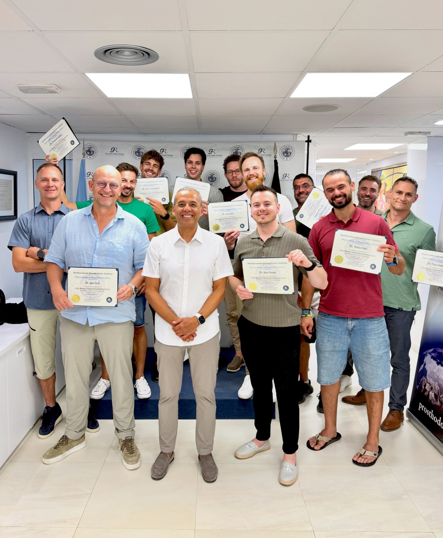 Spoločná fotografia účastníkov kurzu implantátovej protetiky s lektorom a certifikátmi.